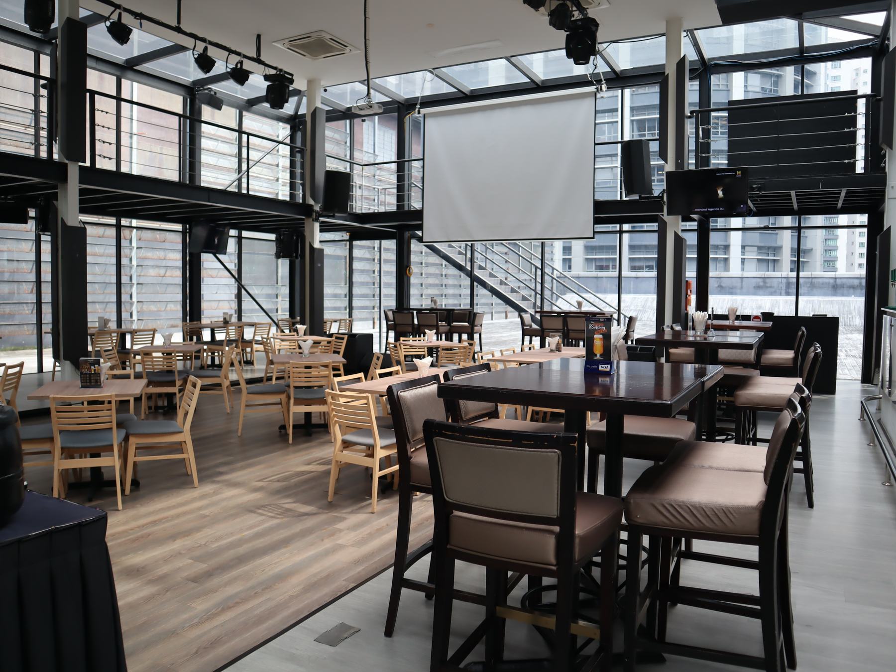Glasshouse interior with projector screen and tables